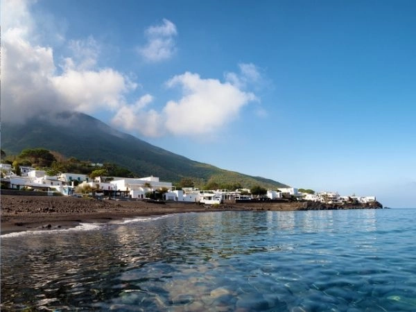 Sabbia nera e acqua limpida della spiaggia ficogrande vicino al vulcano Stromboli, isole Eolie, italia