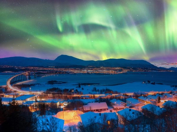 Vedere l'aurora boreale nel cielo sopra Tromsø con il ponte Sandnessundet