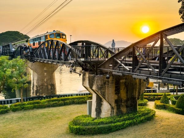 Attraversare il ponte sul fiume Kwai, al tramonto, Kanchanaburi, Thailandia